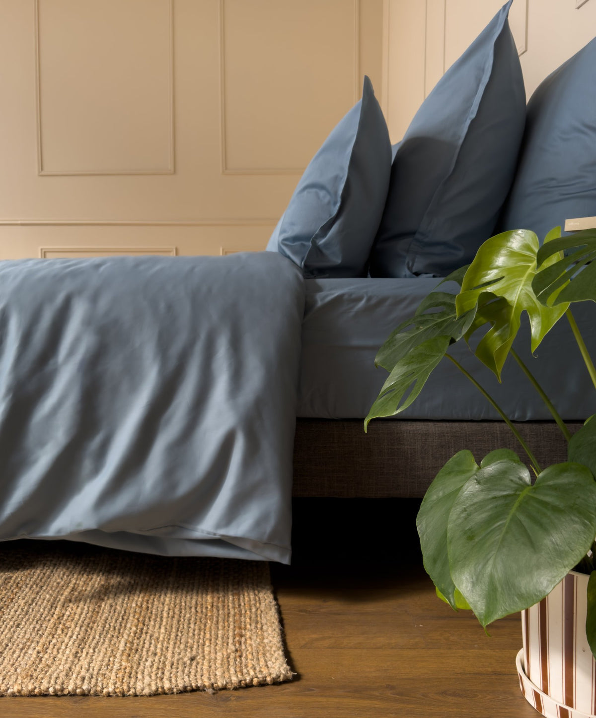 Élastique tête et pied d'un drap-housse en satin de coton bio bleu minéral, bien tendu sur le matelas
