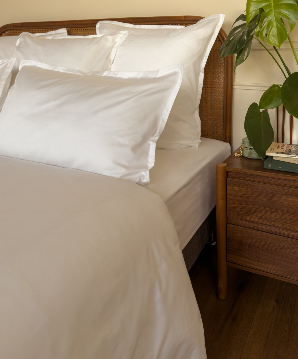 Ourlet soigné d'un drap plat en satin de coton bio blanc, confectionné à la main à La Bresse
