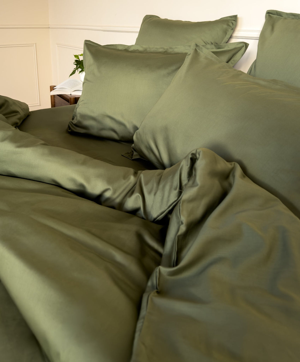 Lit fait avec une housse de couette en satin de coton bio vert olive, linge de lit fabriqué dans les Vosges