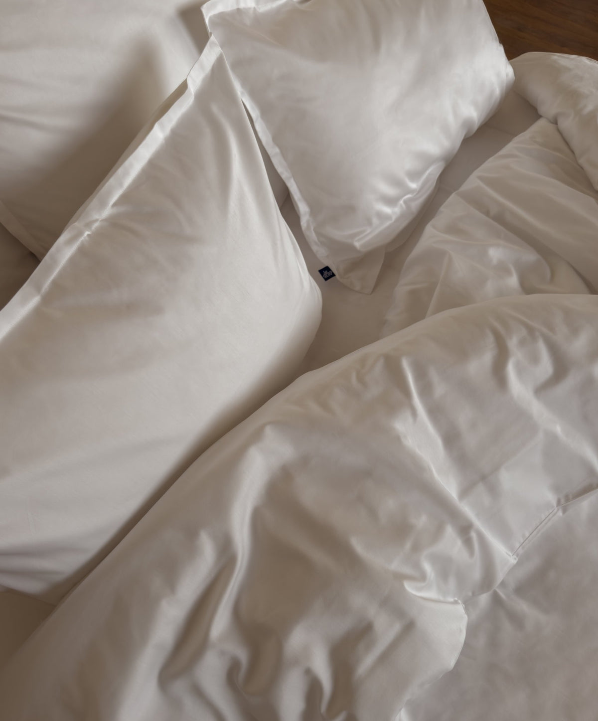 Chambre avec une parure de lit en satin de coton bio blanc, linge de lit fabriqué dans les Vosges #couleur_blanc
