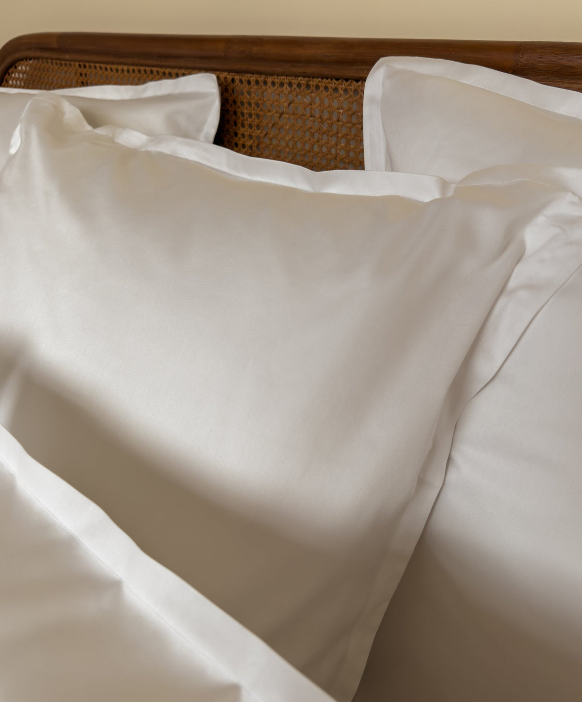 Lit fait avec des taies d'oreiller en satin de coton bio blanc, linge de lit fabriqué dans les Vosges