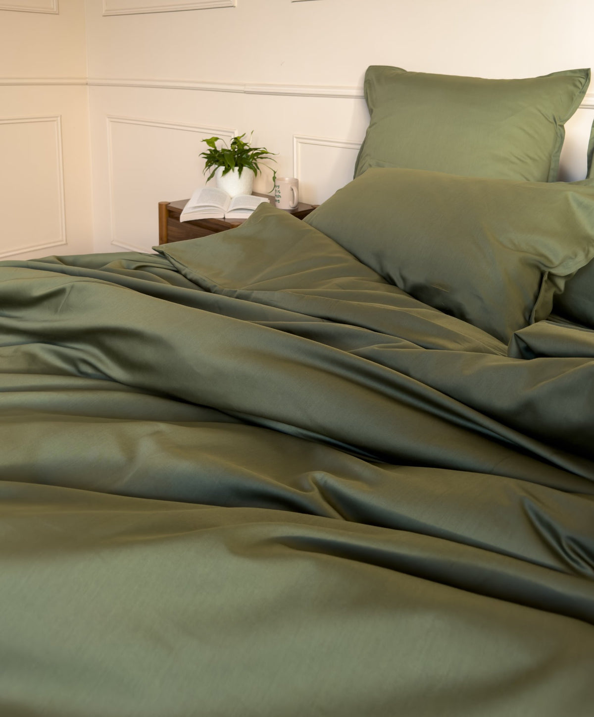 Lit fait avec un drap-housse en satin de coton bio vert olive, linge de lit fabriqué dans les Vosges 