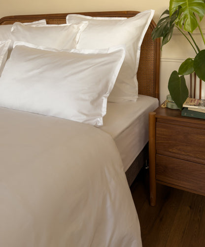 Ourlet soigné d'un drap plat en satin de coton bio blanc, confectionné à la main à La Bresse 