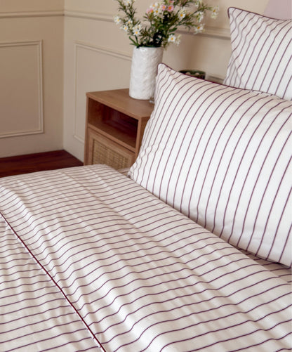 Zoom sur le passepoil de la housse de couette Édition Rose Délicat en percale de coton rayée. 
