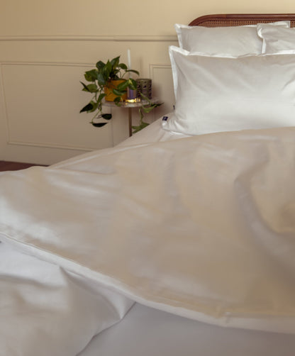 Lit fait avec une housse de couette en satin de coton bio blanc, linge de lit fabriqué dans les Vosges 