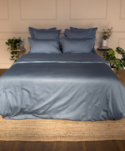 Chambre avec une parure de lit en satin de coton bio bleu minéral, linge de lit fabriqué dans les Vosges #couleur_bleu-mineral