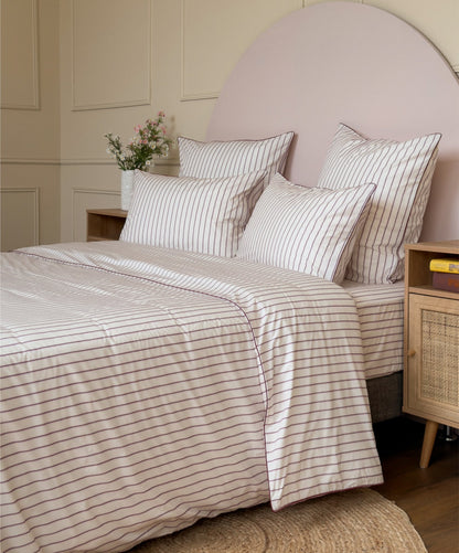 Parure de lit Édition Rose Délicat en percale de coton rayée avec housse de couette, taies d'oreiller et passepoil. #couleur_rose-delicat