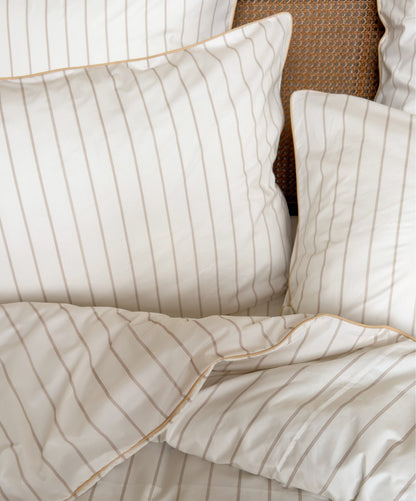 Vue de face de la parure de lit rayée Nuances de Beige avec finition passepoil. 