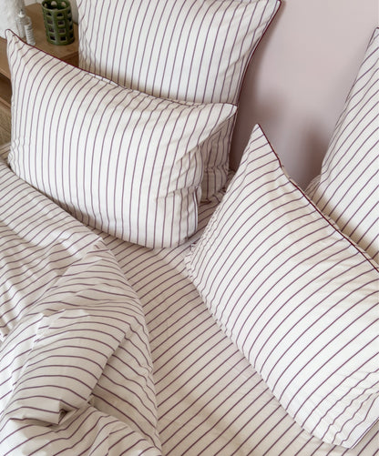 Taies d'oreiller Édition Rose Délicat en percale de coton rayée avec passepoil. 