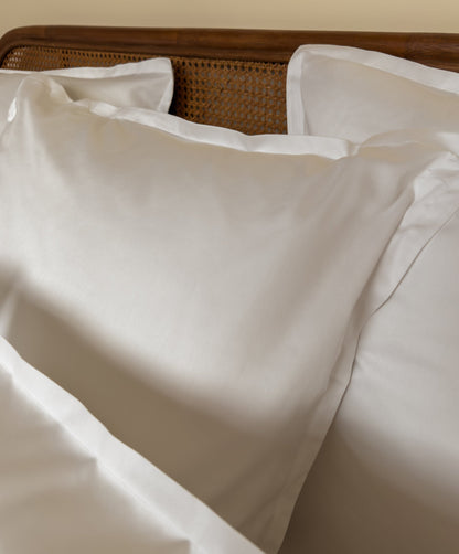 Lit fait avec des taies d'oreiller en satin de coton bio blanc, linge de lit fabriqué dans les Vosges 