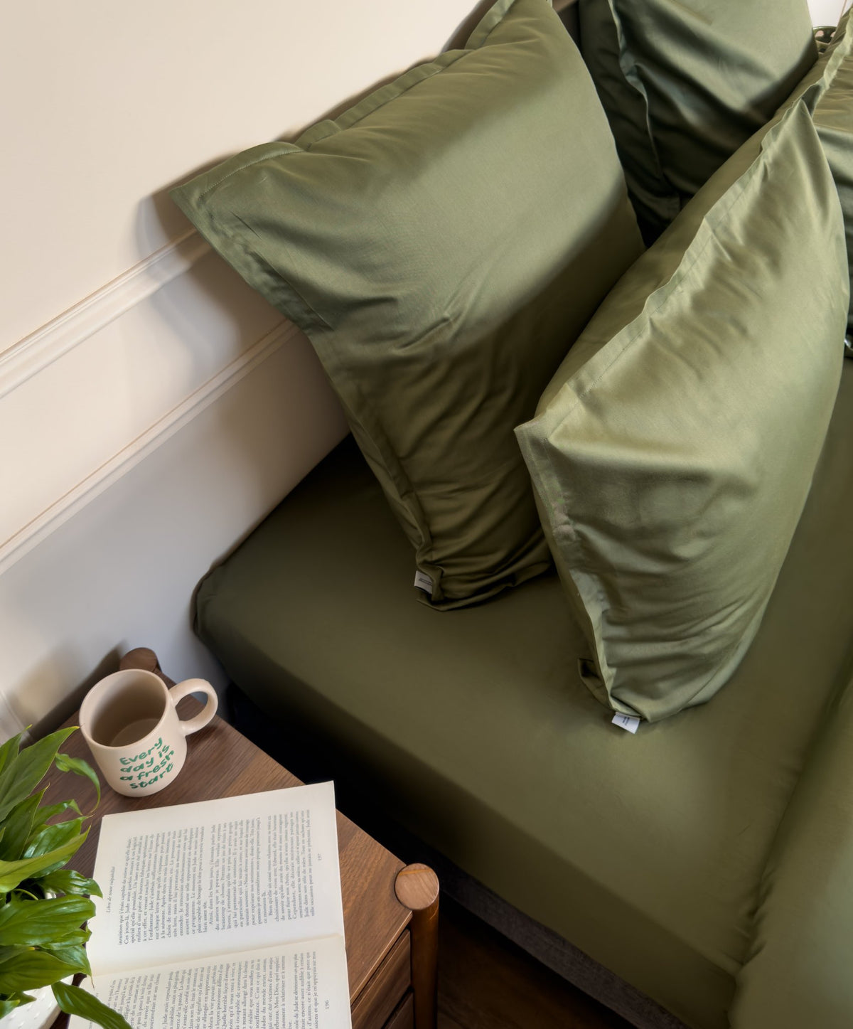 Lit fait avec des taies d'oreiller en satin de coton bio vert olive, linge de lit fabriqué dans les Vosges 